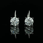 May include: Two gold dangle earrings with a round, clear, sparkling stone in the center of each earring.