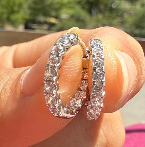 May include: Two white Gold hoop earrings with a row of clear round diamonds stones around the entire hoop.