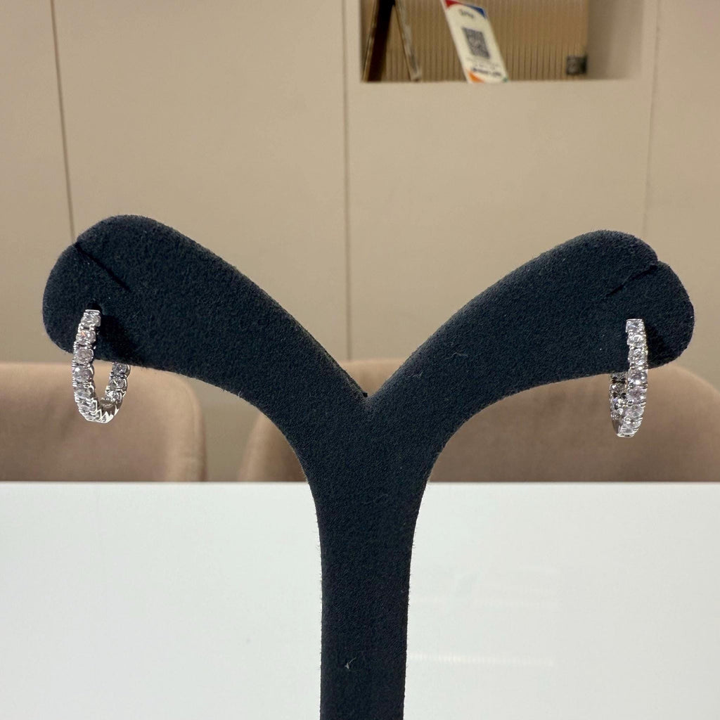 May include: A pair of gold hoop earrings with a row of small clear diamonds around the outside of each hoop.
