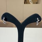 May include: A pair of gold hoop earrings with a row of marquise shaped clear diamonds on each hoop.