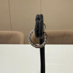 May include: gold hoop earrings with small clear stones set in the metal. The earrings are displayed on a black stand.
